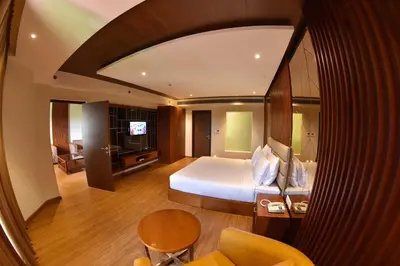 a bedroom with a bed and a living room at THE PEARL VIEW HOTEL in Mulappilangād