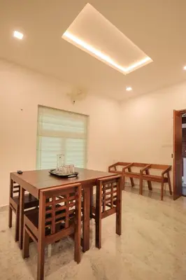 a dining room with a wooden table and chairs at Redstone Villa in Tāzhekkod