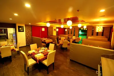 a restaurant with a dining room with tables and chairs at Paravoor Galaxy Hotel in Cherai Beach