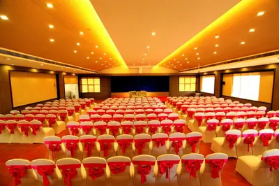 a large room with red and white chairs in it at Paravoor Galaxy Hotel in Cherai Beach