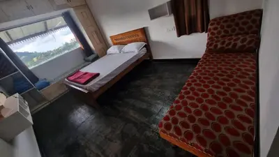 a small bedroom with a bed and a window at Sandiago Villa 2 Bhk House in Ooty