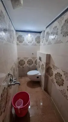 a bathroom with a toilet and a bucket in it at Sandiago Villa 2 Bhk House in Ooty