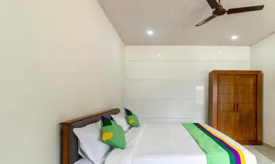 a bedroom with a bed with a wooden headboard at Treebo The Rove with Swimming Pool in Madikeri
