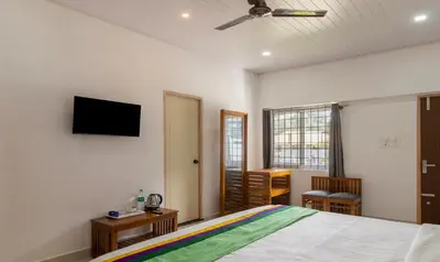 a bedroom with a bed and a flat screen tv at Treebo The Rove with Swimming Pool in Madikeri