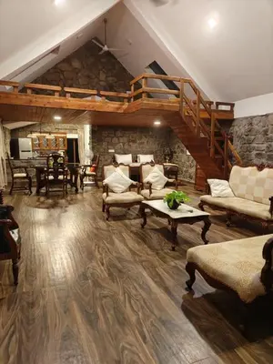 a living room filled with furniture and a staircase at Captain's Cabin in Masinagudi