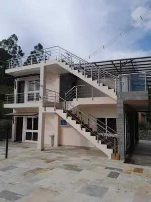 a building with a staircase on the side of it at Ohm Shanthi Kudil in Kodaikānāl