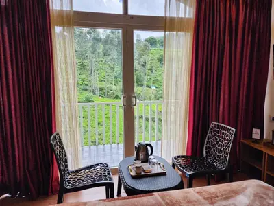 a room with a table and two chairs and a window at Cloud & Mist Inn-Stay with Mountain Views in Kotagiri, Near Ooty in Kotagiri