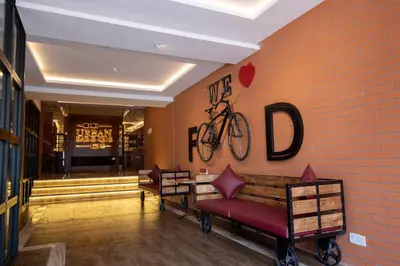 a lobby with a bench and a bike on the wall at Jenneys Residency in Coimbatore