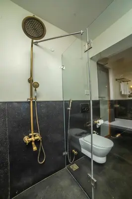a bathroom with a toilet and a glass shower at The Winterfel in Yedapalli