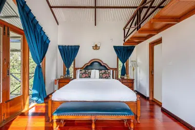 a bedroom with a bed and blue curtains at The Winterfel in Yedapalli