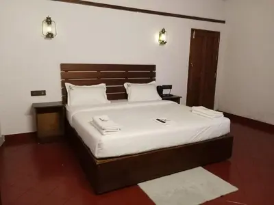 a bedroom with a large bed with white sheets at JK Nature Stay Resorts in Kanthalloor