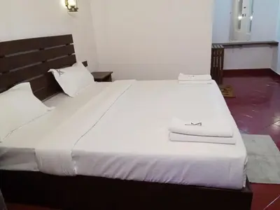 a white bed with a book on top of it at JK Nature Stay Resorts in Kanthalloor