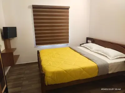 a bedroom with a bed with a yellow blanket at Family Cottage at Merlys Fruit Garden, Thattekkad in Kotamangalam