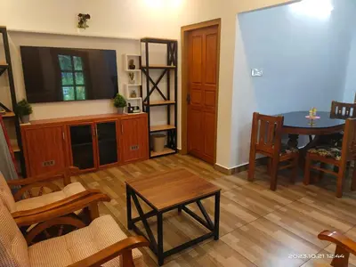 a living room with a table and a dining room at Family Cottage at Merlys Fruit Garden, Thattekkad in Kotamangalam