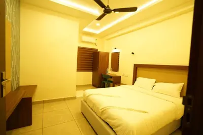 a bedroom with a bed and a ceiling fan at SREENARAYANA TOURIST HOME in Guruvāyūr