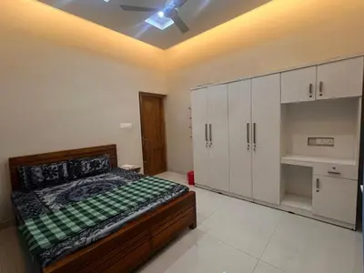 a bedroom with a bed and white cabinets at Chaithanya Residency Near to NIT Kozhikode in Kunnamangalam