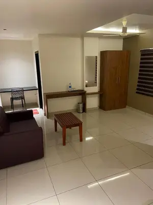 a living room with a couch and a table at Redbell Suites Kizhisseri in Kondotti