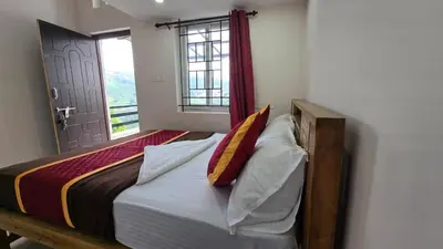 a bedroom with a bed with pillows and a window at Sandy Castle Villa 3 Bhk Homestay in Ooty