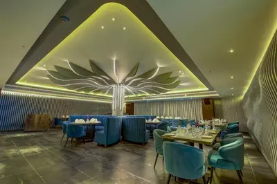 a dining room with tables and blue chairs at Regenta Central Javaji Mysore in Mysore
