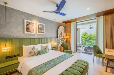 a bedroom with a large bed and a desk at Flora Misty Falls Athirappilly in Athirappilly