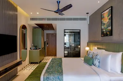a bedroom with a large bed with a ceiling fan at Flora Misty Falls Athirappilly in Athirappilly