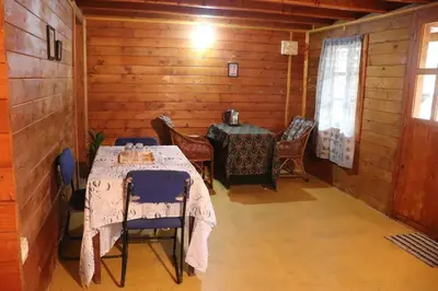 a dining room with a table and chairs in a cabin at Coorg Northbreeze Wooden Stay in Madikeri