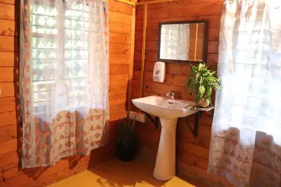 a bathroom with a sink and a mirror at Coorg Northbreeze Wooden Stay in Madikeri