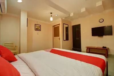 a bedroom with a bed and a tv on the wall at PRANOV RESIDENCY-Luxury in Coimbatore
