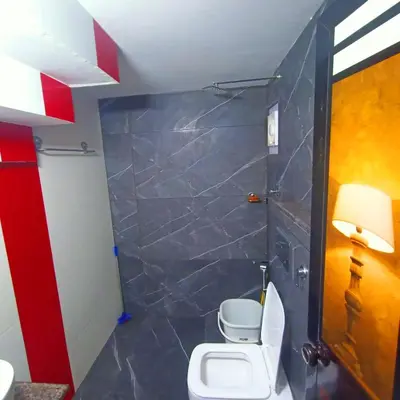 a bathroom with a white toilet in a room at Empire Pool Villa in Meenangadi