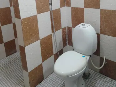a bathroom with a white toilet in a room at Misty Moonrise in Kūkkāl