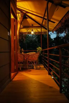 a patio with a table and chairs on a porch at Coffee Cradle Wayanad Luxuorios Private Tree House - Inside 2 Acre Coffee Plantation in Mananthavady