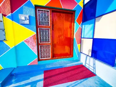 a colorful building with a window in the middle at Sahara Family Homestay in Mysore
