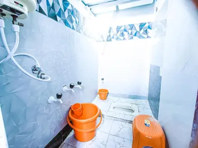 a bathroom with an orange toilet and a shower at Sahara Family Homestay in Mysore
