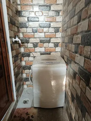 a bathroom with a toilet in a brick wall at Sahara Family Homestay in Mysore