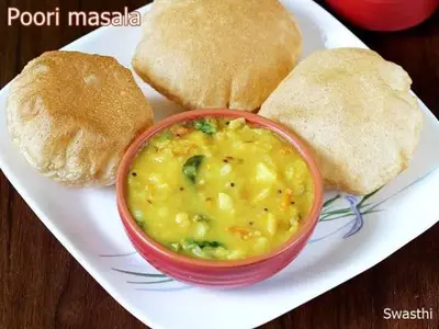 a plate of food with a bowl of soup and bread at Sahara Family Homestay in Mysore