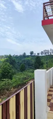 a balcony of a house with a view of a field at Sandy 4 Bhk Homestay - Only Adults Allowed in Ooty