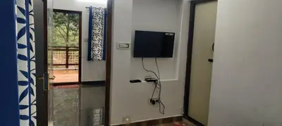 a room with a flat screen tv on a wall at Sandy 4 Bhk Homestay - Only Adults Allowed in Ooty