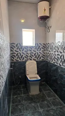a bathroom with a toilet and a window at Golden View Cottage Ooty in Ooty