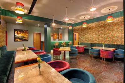 a restaurant with colorful stools and tables in a room at PARK RESIDENCY ARCADIA in Alwaye