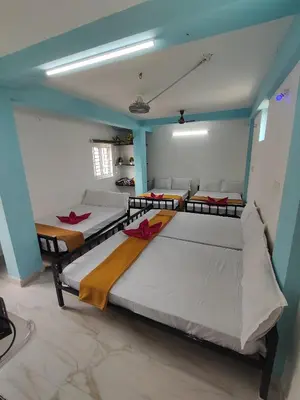 three beds in a room with blue walls at Sri Aksha Residency in Alāndurai