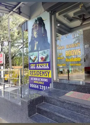 a sign on the side of a building with stairs at Sri Aksha Residency in Alāndurai