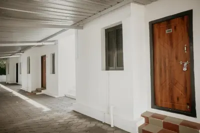 a hallway with a wooden door on a white building at RD VILLA in Perundurai
