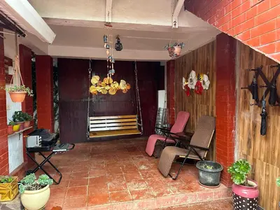 a patio with chairs and a table and a chandelier at Kanjira house in Ooty