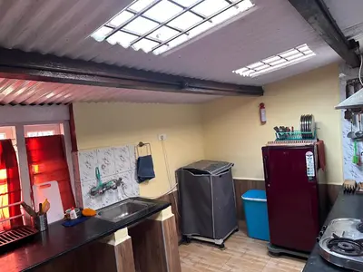 a kitchen with a sink and a red refrigerator at Kanjira house in Ooty
