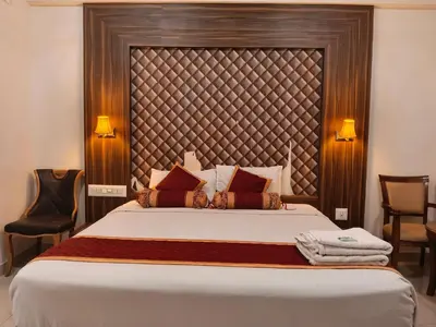 a bedroom with a large bed with a large headboard at Grand Milestone in Mysore