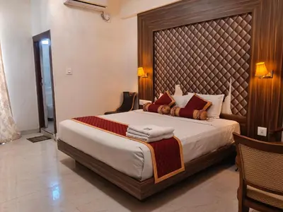 a bedroom with a large bed with a large headboard at Grand Milestone in Mysore