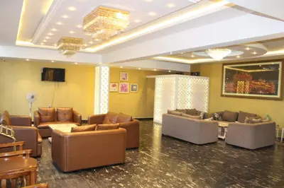 a living room with couches and a tv in a room at Grand Milestone in Mysore