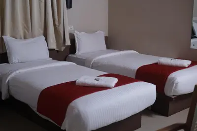 three beds in a hotel room with towels on them at DREAMS AIRPORT RESIDENCY in Nedumbassery