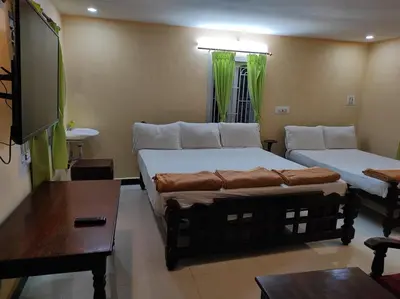 a living room with two beds and a couch at COTTAGE GARDEN DEEPIKAS in Parambikolam