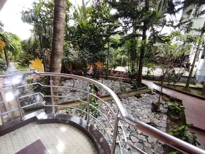 a metal staircase in a park with trees and a sidewalk at COTTAGE GARDEN DEEPIKAS in Parambikolam